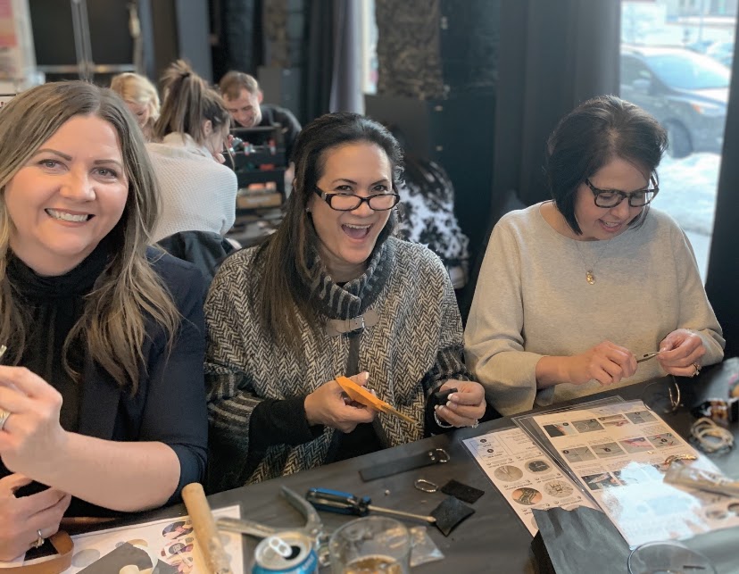 Women gathered around a table working on a creative project together